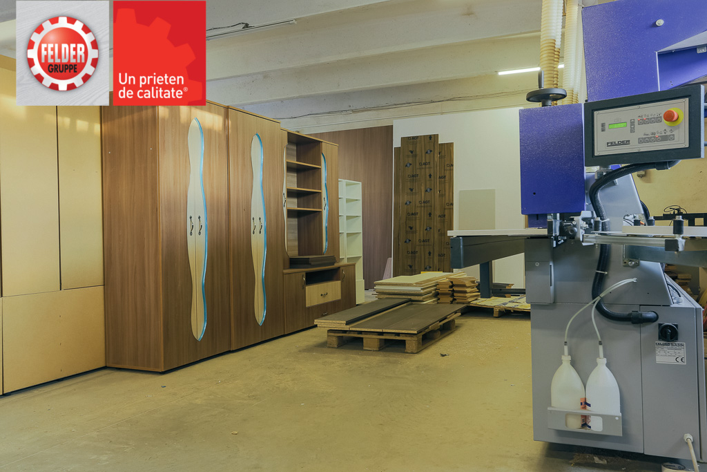 Foto atelier Rody Mob Lux: în stânga imaginii, piese de mobilier gata de livrare. În dreapta, mașina pentru aplicarea automată a foliei pe cant Felder G480