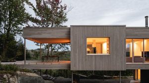 Casa minimalista construída sobre pilares numa floresta perto de Montreal